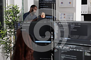 Team of app developers looking at coding algorithms on laptop