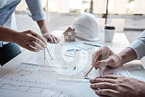 Team of architects or engineering consulting and analyzing working on objects tools and construction drawings inspection,