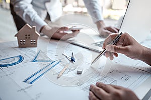 Team of architects or engineering consulting and analyzing working on objects tools and construction drawings inspection,