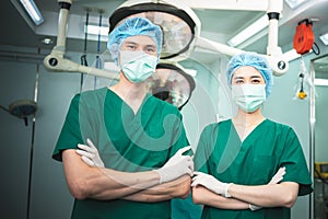 A team of Asian doctors, male and female surgeons Standing in the operating room