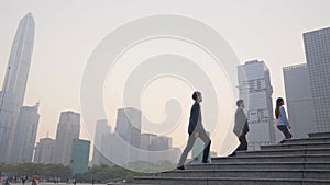 Team of asian office workers ascending steps in city downtown