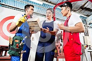 Team of Asian workers discussing product