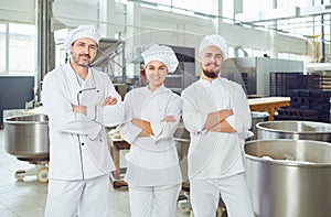 A team of bakers smiles at the bakery.