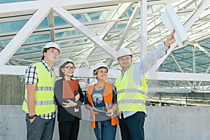 Team of builders engineer architect on the roof of construction site. Building, development, teamwork and people concept