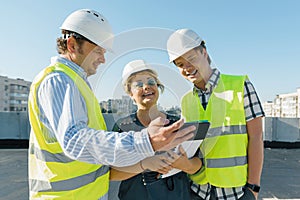 Team of builders engineer architect on the roof of construction site. Building, development, teamwork and people concept