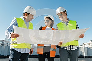 Team of builders engineer architect on the roof of construction site. Building, development, teamwork and people concept