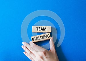 Team Building symbol. Concept word Team Building on wooden blocks. Businessman hand. Beautiful blue background. Business and Team