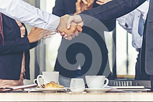 Team Business Partners shaking hands together to Greeting Start up small business in meeting room. Shakehand teamwork partners at photo