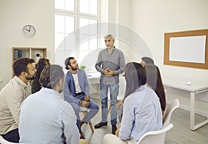 Team of business people or company employees talking during work meeting in office