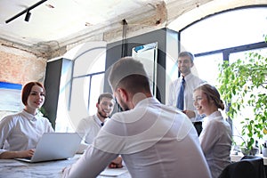 Team of business people having discussion at table in creative office