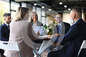 Team of business people having discussion at table in creative office