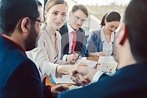 Team of business people negotiating an agreement closing the deal