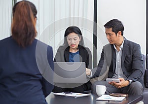 Team of business three people working together on a laptop.