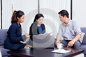 Team of business three people working together on a laptop