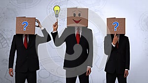 Team of businessman hiding head with box