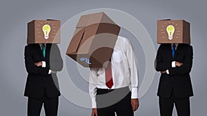 Team of businessman hiding head with box