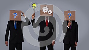Team of businessman hiding head with box and gesturing