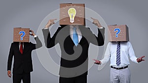 Team of businessman hiding head with box and gesturing