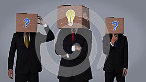 Team of businessman hiding head with box and gesturing