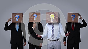 Team of businessman hiding head with box and gesturing
