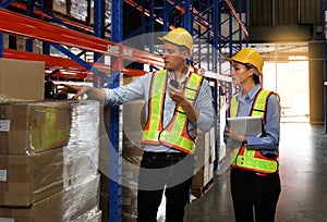 A team of Caucasian male and female engineers stood on a shelf stored in a warehouse. Use radios and clipboards. Check the stock photo