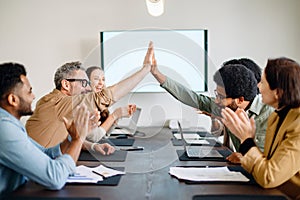 A team celebrates a shared success with high fives