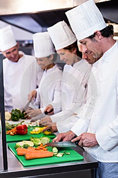 Team of chefs chopping vegetables