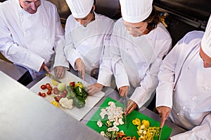 Team of chefs chopping vegetables