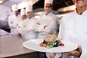 Team of chefs with one presenting a dish