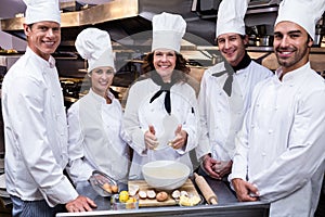 Team of chefs smiling in commercial kitchen photo