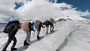 A team of climbers ascending an icy slope on Mt. Everest across the sky above. Clip. People enjoying climbing a snowy