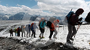 A team of climbers ascending an icy slope on Mt. Everest across the sky above. Clip. People enjoying climbing a snowy