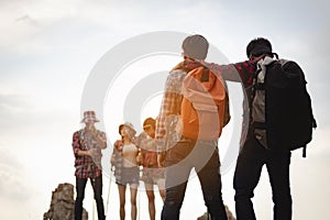 Team of climbers man and woman hiker hiking mountain climbing success stand at the cliff with backpacks on mountain top over.