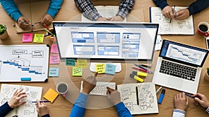 Team collaborating on project with wireframe design on computer screen