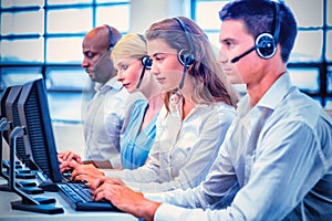 Team of colleagues working on computer with headset