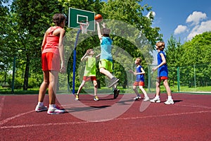 Team in colorful uniforms playing basketball game photo