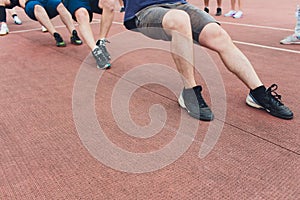 Team competing in tug of war men pull the rope.