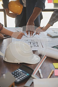 A team of construction engineers talks to managers and construction workers at the construction site. Quality inspection, work