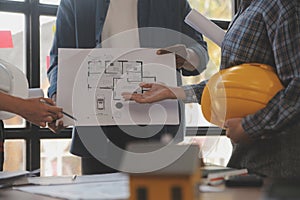 A team of construction engineers talks to managers and construction workers at the construction site. Quality inspection, work