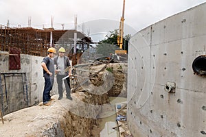 Team of construction workers discussing project details with blueprint in construction site