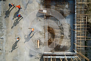 Team of the construction workers works on foundation of contemporary house.