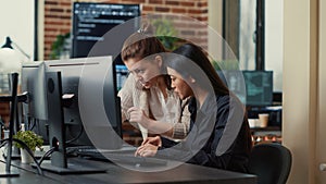 Team of coworkers comparing source codes running on laptop screen and computer monitor