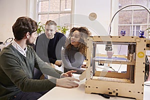 Team Of Designers Working With 3D Printer In Design Studio