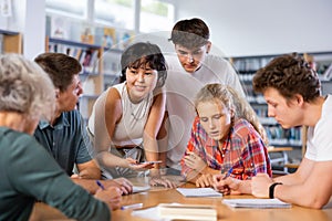 Team of diligent schoolkids during classes in library