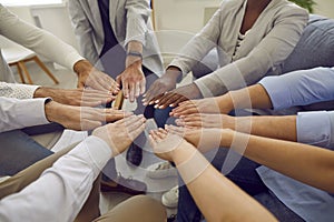 Team of diverse business people join hands to show concept of teamwork, unity and support