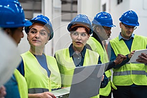 Team of diverse engineers working in robotic factory