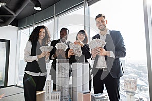 Team of diverse multiethnic business people holding bundle of american dollar cash money