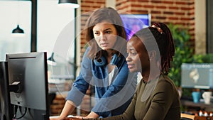 Team of diverse office employees working on multi monitors