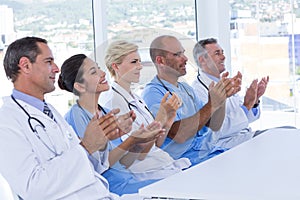 Team of doctors applauding during meeting