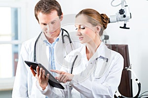 Team of doctors in clinic with tablet computer